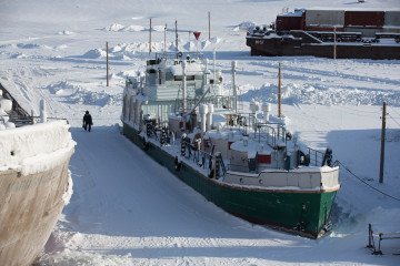 Illustrative image. A worker passes ice-trapped vessels as he walks across the harbor on the Lena River beside Zhatay village, near Yakutsk, Sakha Republic, Russia, on February 15, 2016. (Source: Getty Images)