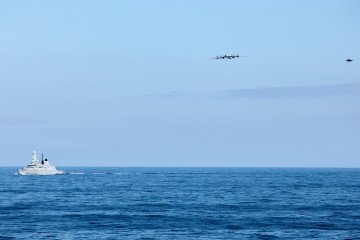 A Russian Tu-142 maritime patrol aircraft flies over the Norwegian Sea as a British Royal Navy warship and F-35B fighter monitor its movements on July 2, 2026. (Source: UK Ministry of Defence)