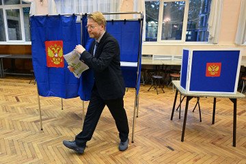 Russia’s liberal Yabloko party leader Nikolay Rybakov walks with his ballot with a marker writing “For peace” during Russia’s parliamentary election at a polling station in Saint Petersburg on September 20, 2026. (Source: Getty Images)