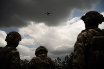 Soldiers from the “Black Sky” battalion of the Spartan brigade look at an agricultural drone, transformed into a front-line delivery cargo, at an undisclosed location in the region of Dnipropetrovsk, Ukraine, on June 14, 2025. (Source: Getty Images)
