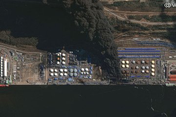Vantor satellite image shows multiple oil storage tanks on fire at the Ust-Luga oil terminal with thick dark smoke billowing eastward. (Source: Satellite image (c) 2026 Vantor via Getty Images)
