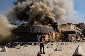A security force member works next to a fire at a supermarket and several shops following a Russian airstrike in Kramatorsk, Ukraine, on August 20, 2026. (Getty Images)