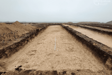 A large excavation site with deep rectangular trenches carved into the earth, prepared ground leveled and measured amid an overcast landscape. (Source: Mariupol website)