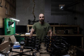 Ukrainian serviceman engineer Anton with the call sign “Atom” poses next to drones in a mobile strike drone workshop of the 25th Airborne Brigade in Donetsk region, Ukraine. (Source: Getty Images)