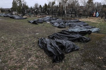 Officials exhume bodies of civilians from a mass grave behind St. Andrew’s Church in Bucha, Ukraine, following Russian attacks. April 10, 2022. (Source: Getty Images)