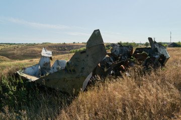The remains of a Russian armoured vehicle sit in a field near a pig farm damaged by a Russian missile strike on August 9, 2025, in Mykilske, Ukraine. (Source: Getty Images)