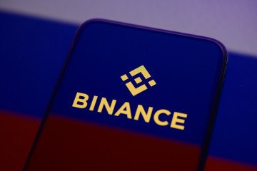 The Binance logo displays on a smartphone screen placed on a reflective surface onto which a Russian flag is projected. (Source: Getty Images) The Binance logo displays on a smartphone screen placed on a reflective surface onto which a Russian flag is projected.
