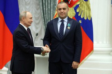 Russian leader Vladimir Putin (L) greets the president of the International Boxing Association Umar Kremlev (Kremlyov) (R) during the meeting with national boxing team at Kremlin on April 22, 2026 in Moscow, Russia. (Source: Getty Images)
