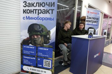 Recruiting staff for the Russian army to fight in the war against Ukraine sit next to propaganda posters in a shopping mall, on February 18, 2025, in Moscow, Russia. Illustrative photo. (Source: Getty Images)