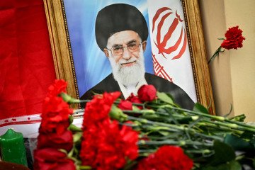 Flowers placed beside a portrait of Iran’s Supreme Leader Ayatollah Ali Khamenei and an Iranian flag at a makeshift memorial outside the Iranian Embassy in Moscow, Russia, on March 2, 2026. (Source: Getty Images)
