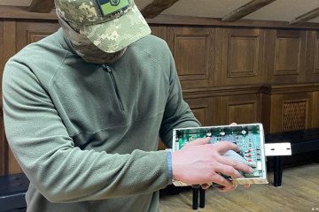 A Ukrainian military intelligence officer displays Infineon transistors recovered from a Russian UAV to Deutsche Welle. (Source: Mykola Berdnyk/DW)