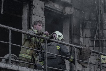 Bomberos trabajan dentro de un edificio quemado en Kyiv tras el ataque ruso contra la capital ucraniana.