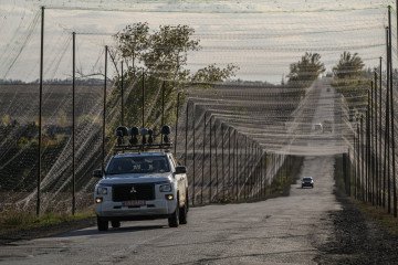 A vehicle equipped with signal jammers drives under anti-drone nets near Oleksandriya, eastern Ukraine, October 2, 2025. (Source: Getty Images)