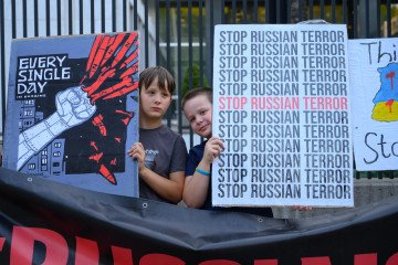 Children hold signs as they rally outside the embassy of the United States of America in Warsaw, Poland, on August 14, 2025. Illustrative photo. (Source: Getty Images)