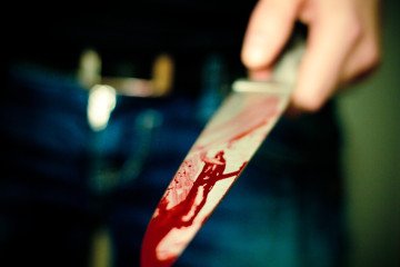 A bloodied knife lying on a dark surface. Illustrative photo. (Photo: Getty Images)
