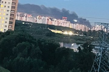 Smoke rises in the distance behind residential high-rises following a reported drone strike on Moscow region overnight August 18, 2026. (Source: Exilenova+)