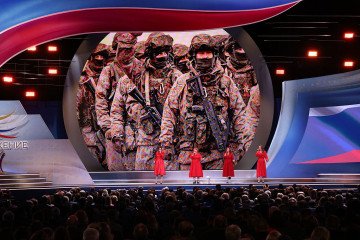 Female singer group perfrom at a Russian pro-war event as pictures of Russian military officers seen on the backgroud. (Source: Getty Images)