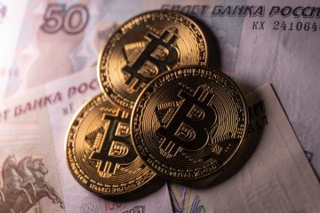 In this photo illustration, novelty Bitcoin tokens are photographed besides Russian rouble bank notes, on January 12, 2025 in Bath, England. (Source: Getty Images)