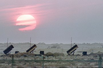 Three batteries of the US-made Patriot anti-missile missiles are lit up by the sunset on 25 January 1991 in the Saudi Arabian desert during the Gulf War against Iraq. (Source: Getty Images)