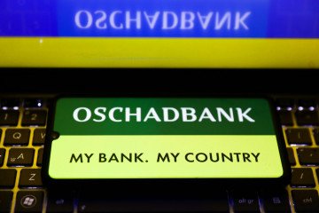 Oschadbank logo is displayed on a mobile phone screen photographed for the illustration photo taken in Krakow, Poland on February 15, 2022. (Source: Getty Images)