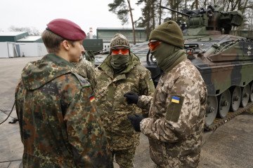 A German Bundeswehr Major speaks to members of the Ukrainian military who are learning to operate Leopard tanks and Marder infantry fighting vehicles during a press date at a training ground. (Source: Getty Images)