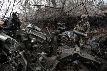 A soldier from the 44th Hetman Danylo Apostol Artillery Brigade of the Ukrainian Armed Forces holds a 155 mm shell by an M777 howitzer during a combat mission in the Dnipropetrovsk region, Ukraine. (Source: Getty Images)