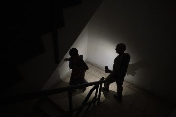 Crimea Enforces Emergency Power and Fuel Rationing After Ukrainian Strikes Hit Kerch Oil Hub People are walking down the stairs in the dark. Illustrative photo. (Source: Getty Images)