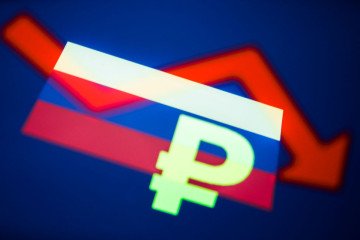 Russian flag and Russian ruble symbol displayed on phone screens and an illustrative stock graph displayed on a screen are seen in this multiple exposure illustration photo taken in Krakow, Poland on February 28, 2022. (Source: Getty Images)