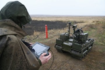 A Russian operator controls a Kurier unmanned ground vehicle armed with a machine gun. (Source: InformNapalm)