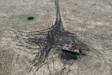 Artillery and mortar craters pierce the ground next to a destroyed Russian tank, on October 23, 2022, in Kam’yanka, Kharkiv region, Ukraine. (Source: Getty Images)