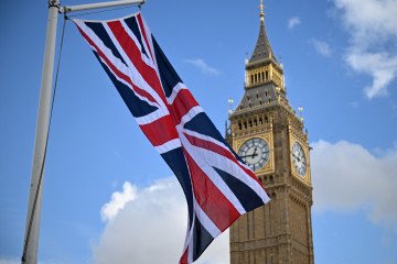 A worker raises a Union flag opposite the Elizabeth Tower, known more commonly after the name of bell inside, Big Ben, at the Houses of Parliament in central London on October 22, 2025. (Source: Getty Images)
