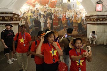 Vietnamese tourists take photos in front of a Soviet-era mural depicting installed at the Kievskaya metro station, on May 15, 2026 in Moscow, Russia. (Source: Getty Images)