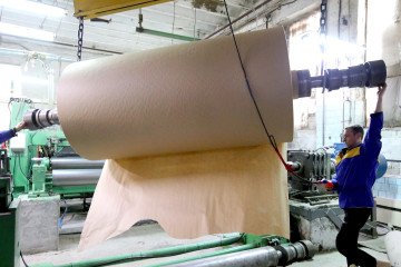 Workers navigate a roll of wrapping paper in a shop at the Zmiiv Paper Factory, Zmiiv, Kharkiv Region, northeastern Ukraine. Illustrative photo. (Source: Getty Images)