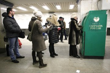 Customers line up to withdraw cash from an ATM operated by OAO Sberbank in Moscow, Russia, on March 22, 2013. (Source: Getty Images)