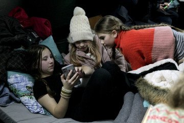 Girls rest at a mobile heating point in the Desnianskyi district of Kyiv, Ukraine, on January 22, 2026. Illustratuve photo. (Source: Getty Images)