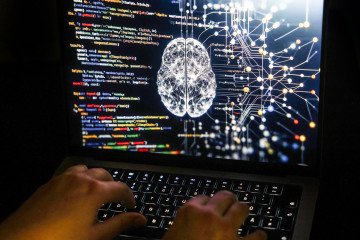 A person works at a computer with an illustrative image generated by artificial intelligence on the screen, showing code from various programming languages and a neural network diagram. (Source: Getty Images) A person works at a computer with an illustrative image generated by artificial intelligence on the screen, showing code from various programming languages and a neural network diagram. (Source: Getty Images)