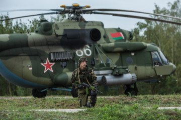 A Belarusian soldier guards a helicopter at the Asipovichy military training ground during the Zapad 2017 military exercises on September 18, 2017 in in Asipovichy, Belarus. (Source: Getty Images)