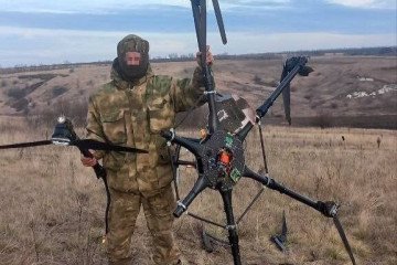Russian soldier standing with downed Ukrainian Vampire heavy bomber drone.