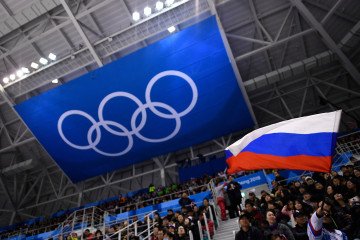 Russian Olympic Committee Reinstatement Triggers Calls to Suspend EU Funding for IOC A spectator waves the Russia flag during the men's preliminary round ice hockey match between the Olympic Athletes from Russia and Slovenia during the Pyeongchang 2018 Winter Olympic Games on February 16, 2018. (Source: Getty Images)
