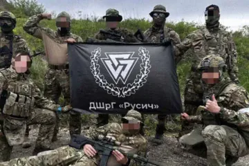 Members of the Russian neo-Nazi paramilitary group Rusich pose with their unit flag during combat operations in Ukraine. (Source: Russian media)