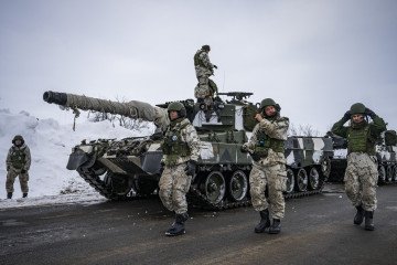 Finnish soldiers of the Finnish-Swedish Division walk next to the Leopard 2A6, on March 9, 2024, on the Finnish side of the Kivilompolo border crossing between Finland and Norway, above the Arctic Circle. (Source: Getty Images)