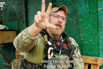 A US Army veteran serving with the Ukrainian Armed Forces flashes a trident hand sign during an interview. (Source: 128th Brigade)