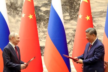 Russia and China Deepen Logistics Ties With New Cross-Border Rail Expansion Russia's leader Vladimir Putin and China's President Xi Jinping exchange documents during a signing ceremony following their talks in Beijing on May 20, 2026. (Source: Getty Images)