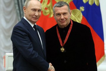 Russian leader Vladimir Putin (L) congratulates television propagandist Vladimir Solovyov (R) during an award ceremony at the Kremlin, on December 24, 2025, in Moscow, Russia.