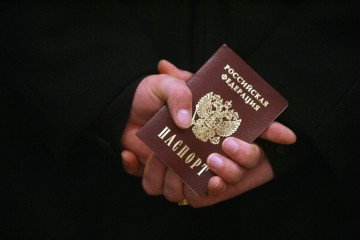 How Russian Forces Use "Illegal-2026" Raids to Force Passports in Temporarily Occupied Ukraine A man holds his Russian passport. Illustrative image. (Source: Getty Images)