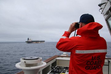 A US Coast Guard official looks through binoculars at the ship Marinera (Ex-Bella 1) in this handout image released January 7, 2026. (Source: via Reuters) A US Coast Guard official looks through binoculars at the ship Marinera (Ex-Bella 1) in this handout image released January 7, 2026. (Source: via Reuters)
