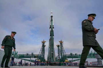 Law enforcement officers walk past the Soyuz-2.1a rocket booster with the Soyuz MS-24 spacecraft at the launch pad at the Russian-leased Baikonur cosmodrome in Kazakhstan. (Source: Getty Images)