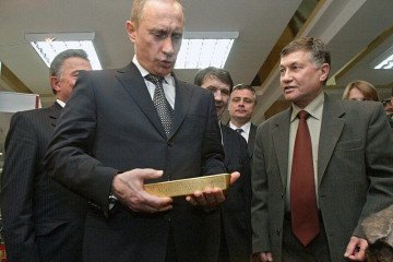 Russian leader Vladimir Putin holds a gold bar while visiting the Central Depository of the Bank of Russia on January 24, 2011, in Moscow.