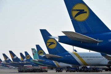Pasajeros en un aeropuerto ruso frente a pantallas de vuelos cancelados tras un ataque de drones ucranianos en la retaguardia.