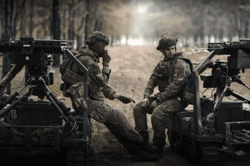 Ukrainian soldiers of the 3rd Army Corps sit beside ground robotic systems used for frontline logistics and evacuation missions.